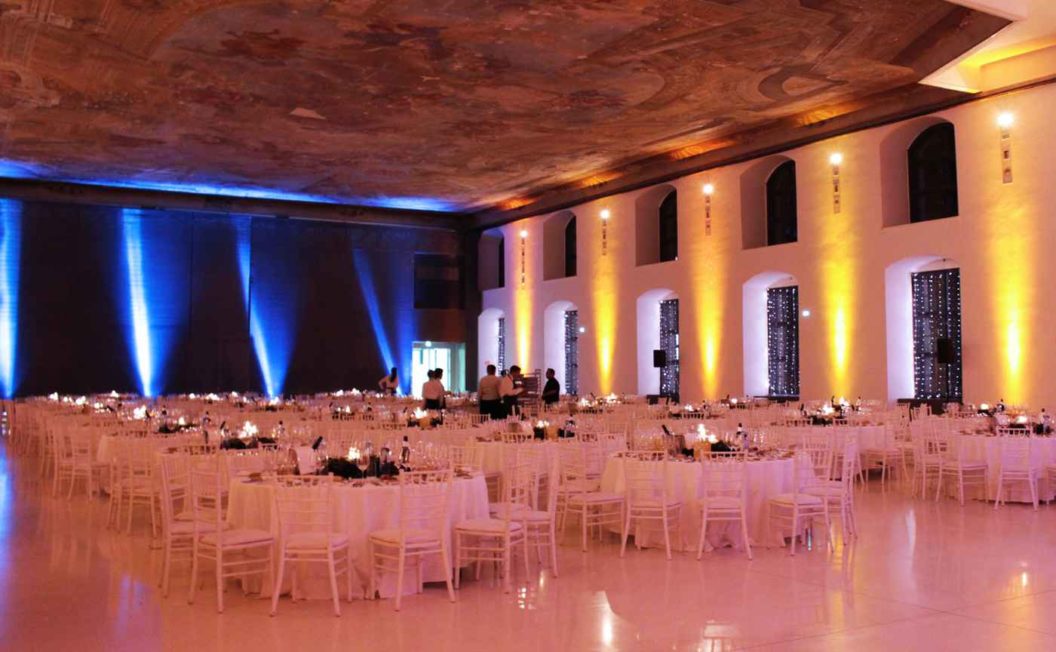 Blaue und gelbe Scheinwerfer an der Wand als Ambientebeleuchtung gemietet bei Gala Dinner